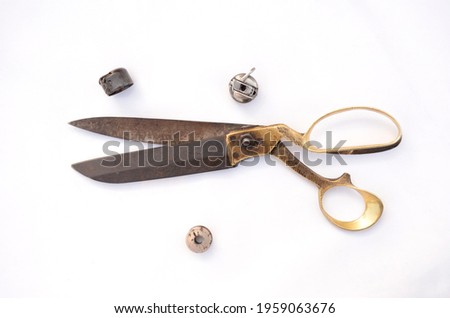 Old metal brass scissors with metal bobbins isolated on white background