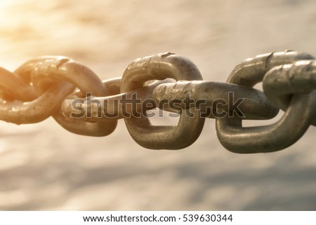 Old metal chain on water background in the sunlight