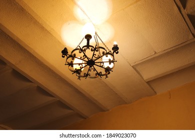 An old metal chandelier in a yellow light