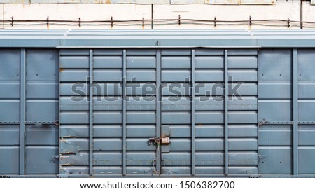 old metal door with a large padlock in a warehouse, garage. Front view of a blue container