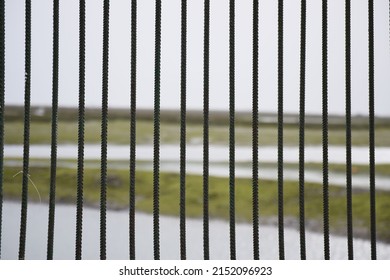 Old, Metal Fence Bars On A Blurred Rural Area