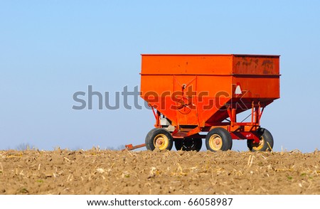 Old metal grain wagon standing in a corn field with copy space
