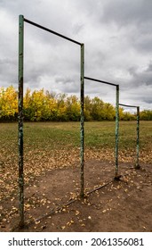 Old Metal Horizontal Bar On A Rustic Playground. High Quality Photo