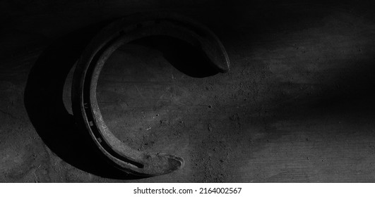 Old Metal Horseshoe On Wood Background In Dark Moody Black And White With Wood Texture For Western Equine Horse Concept.