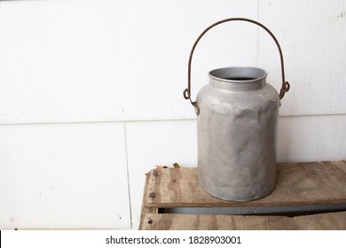 Old Metal Milk Pail On Brown Wood Crate With White Background Blank Space