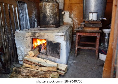 Old metal open stove door with burning flame wood. Old style cooking with large pot on open fire. Traditional cooking on log wooden fire with visible flames and smoke