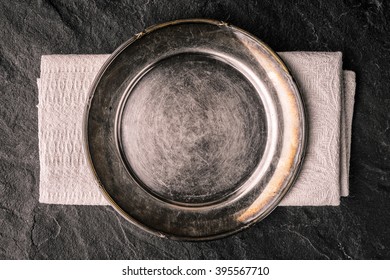 Old Metal Plate On The Dark Stone Table Top View