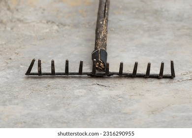 Old metal rake for cleaning leaves and grass, close-up.Yard area cleaning.