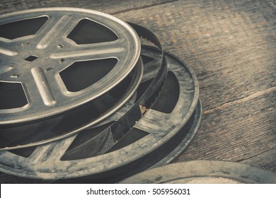 Old metal reel of film lie on a wooden table