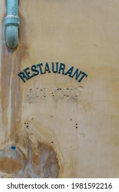 Old Metal Restaurant Sign On A Weathered Wall