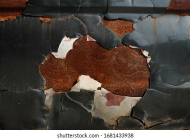 Old metal sheet with peeling off surfaces.  Three layers, dark navy, white paints and rusty base material.  Industrial and background categories.