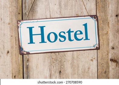 Old Metal Sign In Front Of A Rustic Wooden Wall - Hostel