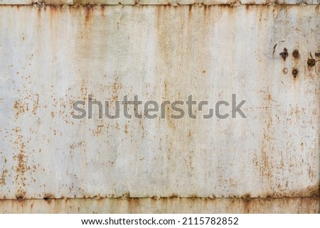 Old metal surface in white. Connections of sheets of iron are visible. There are holes, pockets of corrosion and streaks of rust. Background.Texture. 