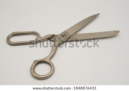Old metal tailor scissors on a white background.
