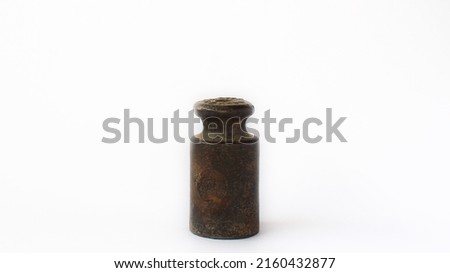 old metal weight tool used for measurement in a white or isolated background.