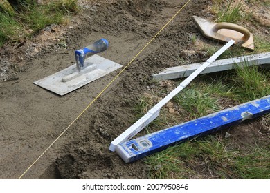 old metal and wooden tools for construction or renovation. laying cement or concrete foundation for the garden fence. do it yourself 