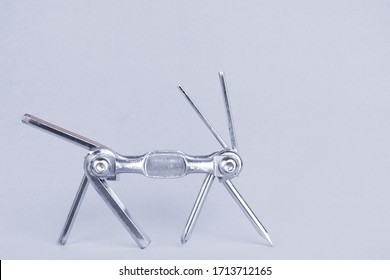 Old Metallic Red Bike Multi-tool Walks For Repair And Service On A Grey Background. Bicycle Multifunction Hand Tool Like An Animal With 4 Legs, Tail And 2 Horns. Black And White Monochrome.