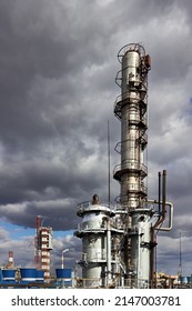 Old Methanol Distillation Rectification Refinery Column Towers And Reactors Under Stormy Sky With Dark Clouds Background At Chemical Plant Enterprise. Industrial Background Vertical With Copy Space.