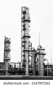 Old Methanol Distillation Rectification Refinery Column Towers And Reactors Under Grey Sky At Chemical Plant Enterprise. Industrial Black And White BW Background Vertical With Copy Space.