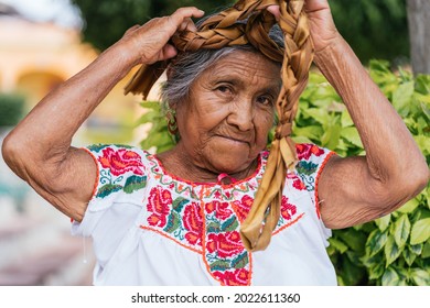 Old Mexican Woman Combing Hair. Adult Woman Looking At Camera, Wears Typical Mexican Costume