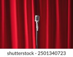 Old microphone on theater stage on red curtains background. Concept stand up, comedian show banner