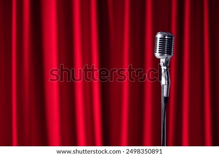 Old microphone on theater stage on red curtains background. Concept stand up, comedian show banner
