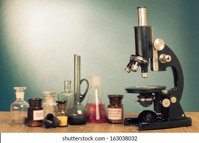 Old Microscope And Laboratory Glass On Table