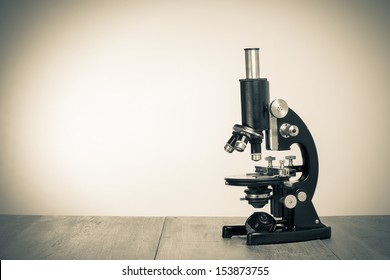 Old microscope on table for vintage science background