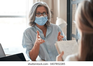 Old Middle Aged Female Mentor, Teacher, Hr Manager Wearing Face Mask Training Young Worker Intern, Teaching Student, Interviewing Job Seeker At Meeting In Office. Social Distance And Safety At Work.