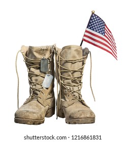 Old military combat boots with the American flag and dog tags, isolated on white background. Memorial Day or Veterans day concept.