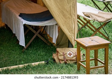 An Old Military Field Hospital With Retro Tents And Vintage Medical Beds With Red Cross. Mobile Clinic For The Treatment Of Soldiers Of The Early Twentieth Century - Moscow, Russia, June 13