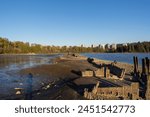 Old Mill Site Park in Port Moody BC as a historical significance (old sawmill) along the shoreline offering picturesque views of Burrard Inlet during sunset. 