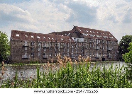 The old millhouse, now flats, on the river Great Ouse, Godmanchester, Huntingdon, Cambridgeshire, England.