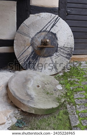 old millstones in front of a barn