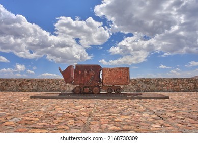 Old Mining Car On Stone Patio With Blue Sky In The Background, No People

