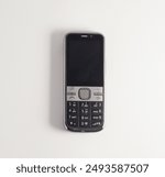 Old mobile phone with black screen, isolated on white.