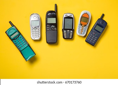 Old mobile phones on yellow background
