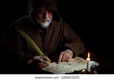Old monk in the Middle Ages writes message