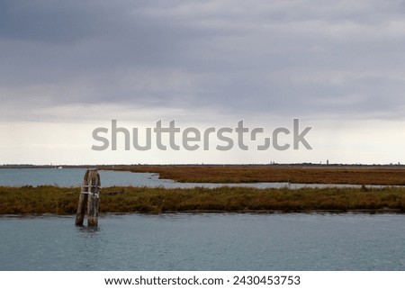Old mooring post and uninhabited islands of Venetian lagoon. View from Burano island, Venice, Italy. Foto stock © 