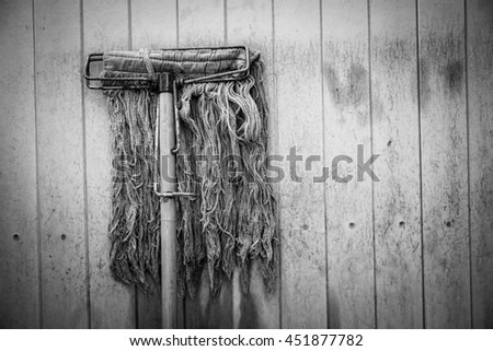 Old Mop with dirty wooden plank wall - Concept background - Black and White