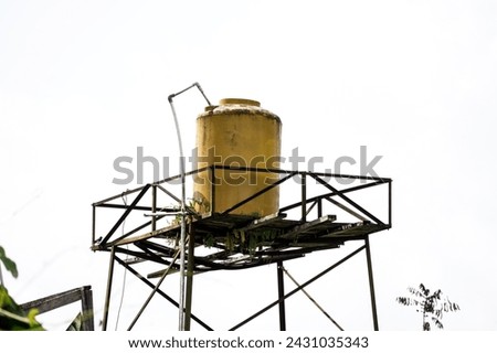 Old and mossy orange water tank tower. Water torrent and storage for house.