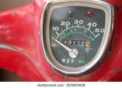 Old Motor Bike Meter Close-up Shot.Scooter Scratched Speedometer Closeup View.Speedometer Dial On A Red Old Scooter Or Moped