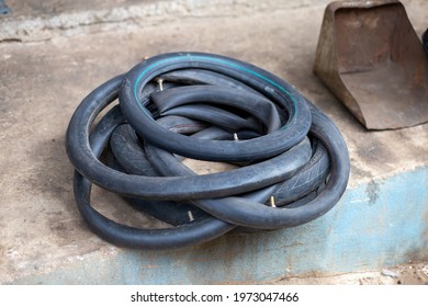 An Old Motorbike Inner Tube Sits On The Floor In A Motorbike Repair Shop. To Bring It Back And Use It Again