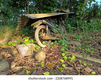 An Old Motorbike Surrounded By Weeds