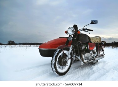 Old Motorcycle With Sidecar In Winter Field