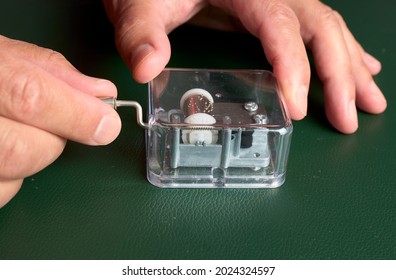 Old Music Box. Hands Of A Man Moving The Crank