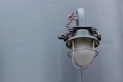 Old Navigation Light Lamp On Ship. Deck Lantern With Metal Protection On Wall. Background With Copy Space
