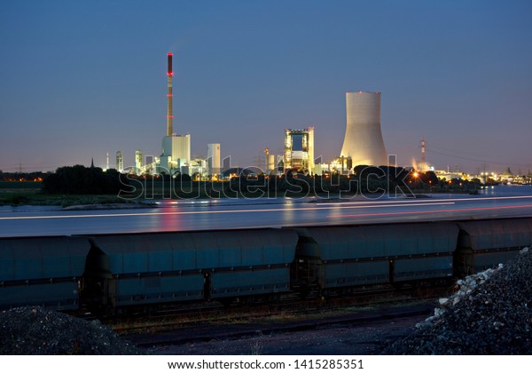 Old\
and new coal power stations side by side with reflection in the\
water and night blue sky. The new cooling tower has a height of\
180m which makes it one of the highest in the\
world.