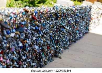 Old and new padlocks with names and dates written on them lock on a bridge as a sign of love in San Antonio, Texas.