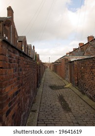 Old Northern British Cobbled Street Alleyway With Garden Walls